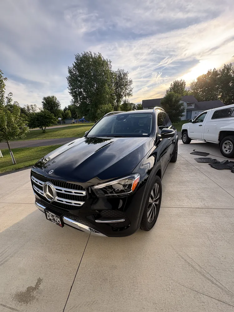 Freshly detailed black Mercedes-Benz GLE gleaming in a driveway at sunset
