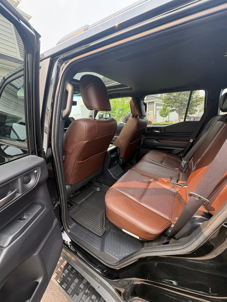 Freshly detailed saddle-brown leather interior in a customer's driveway by Grandvista Mobile Detailing